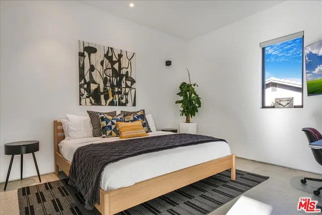 a bedroom with bed and a potted plant