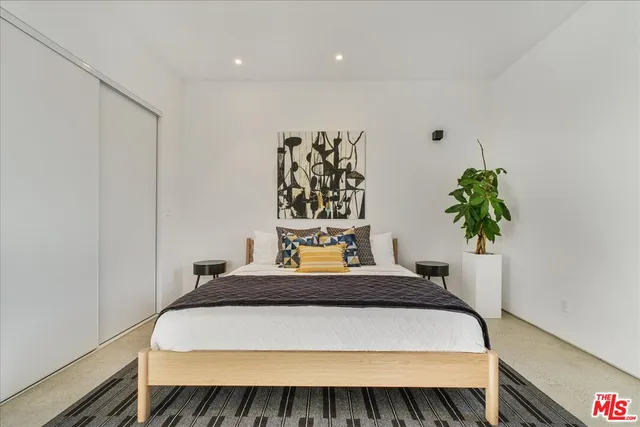 a bedroom with a bed and a potted plant