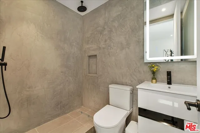 a bathroom with a sink a toilet and a mirror