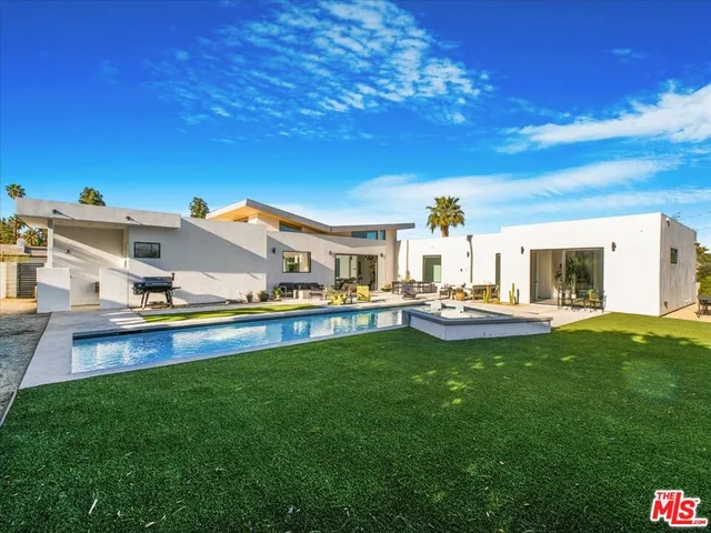 a view of a house with swimming pool and a yard