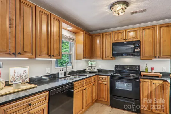 a kitchen with granite countertop a sink stainless steel appliances and cabinets