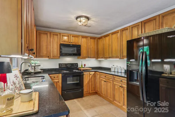 a kitchen with stainless steel appliances granite countertop a stove top oven a sink dishwasher a refrigerator and cabinets with wooden floor