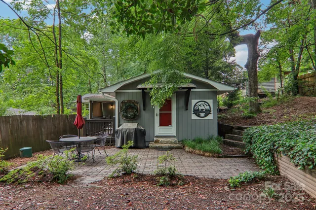 a view of a chair and table in backyard of the house