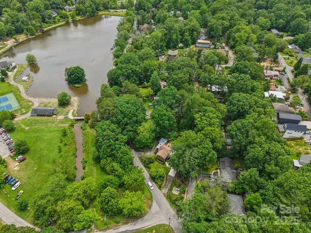 an aerial view of a house with a yard and lake view