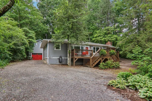 a view of a house with large trees and a yard