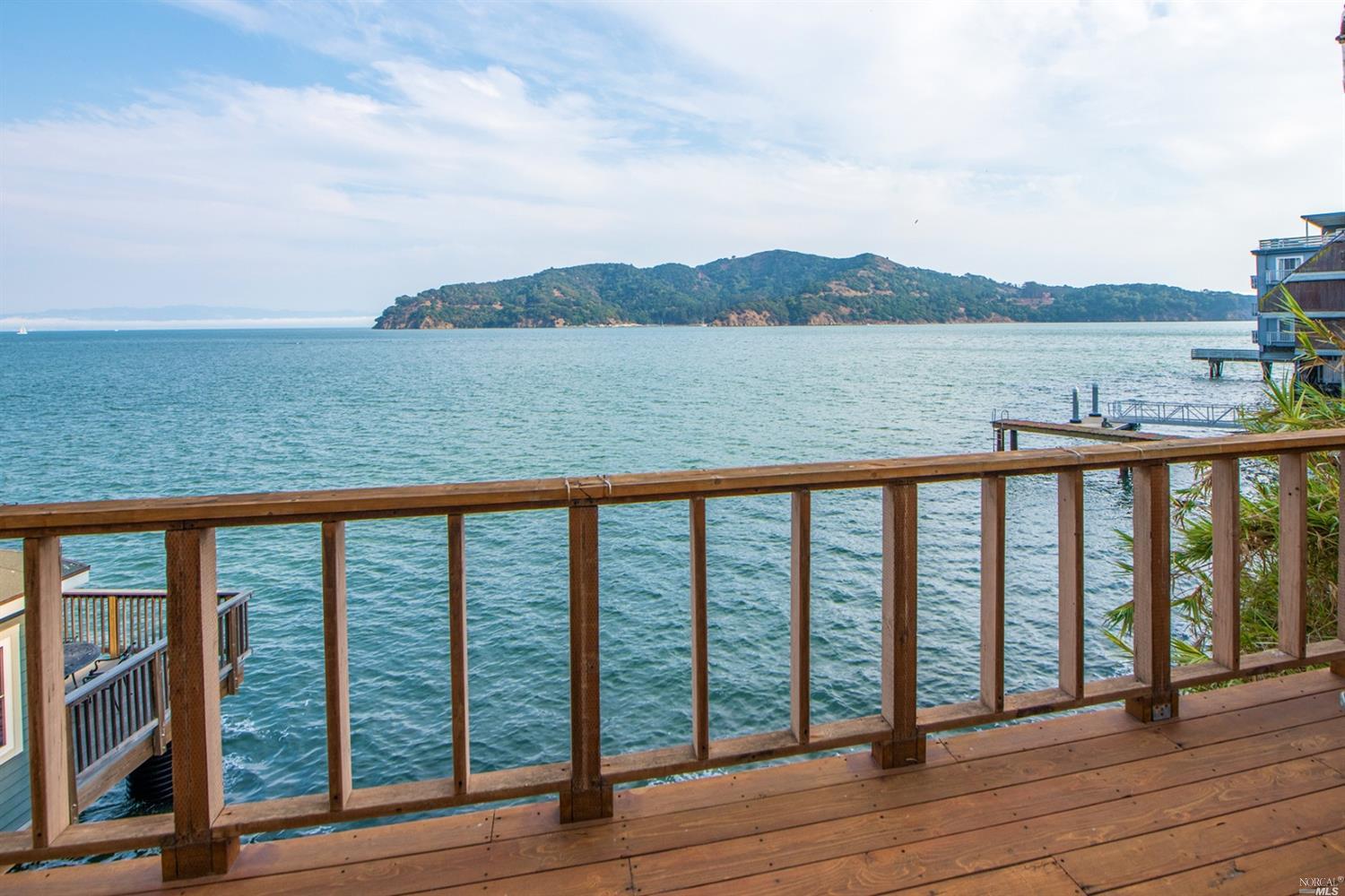 a balcony with wooden floor and lake view
