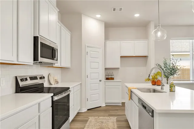 a kitchen with a sink a stove and cabinets