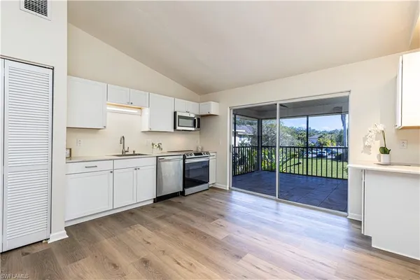a kitchen with granite countertop a sink cabinets and wooden floor