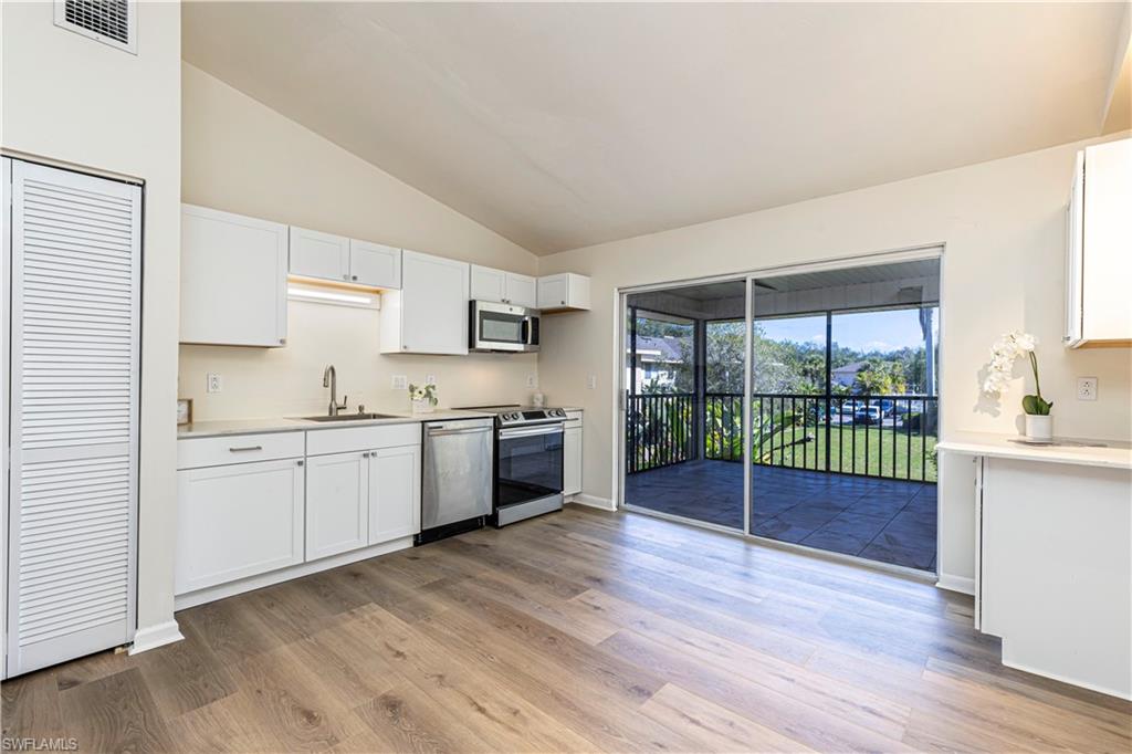 a kitchen with granite countertop a sink cabinets and wooden floor