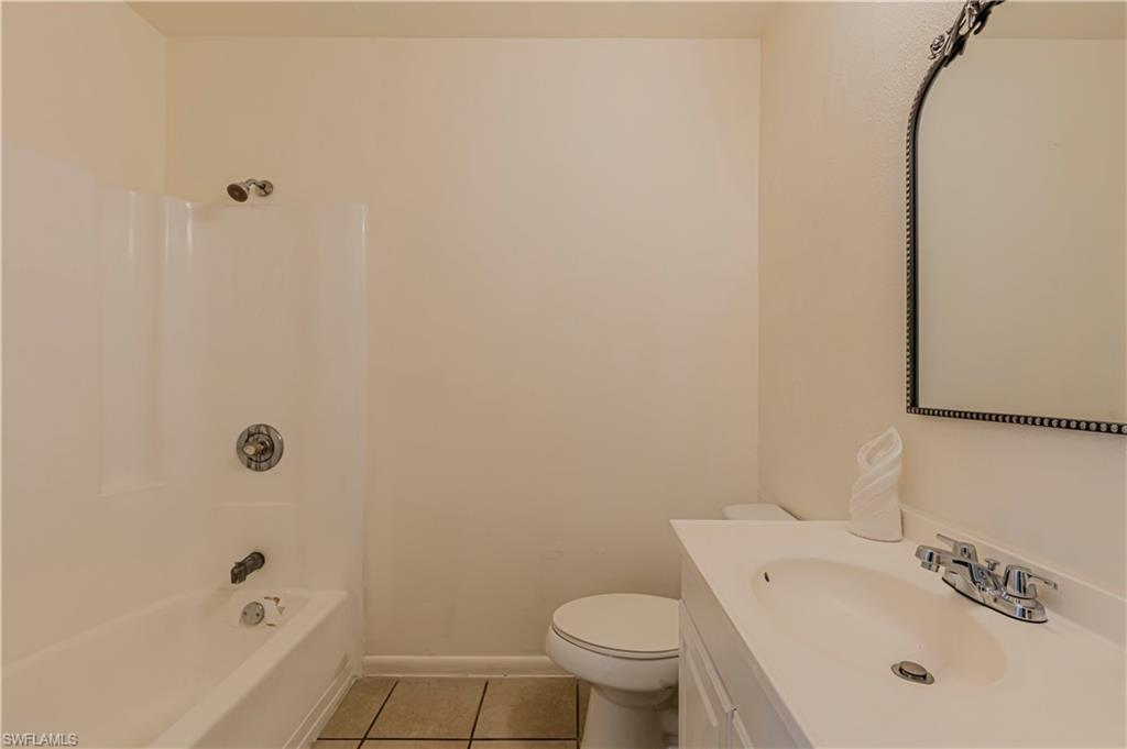 5434 16th Place Southwest, Unit D3 Golden Gate, FL 34116 - Photo 11 of 17 a white bath tub sitting next to a white toilet and sink