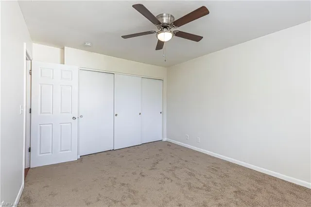 an empty room with a ceiling fan and a window