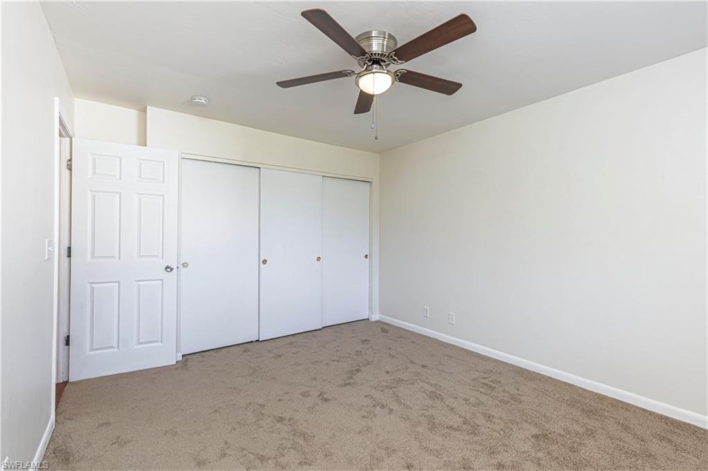 5434 16th Place Southwest, Unit D3 Golden Gate, FL 34116 - Photo 12 of 17 an empty room with a ceiling fan and a window
