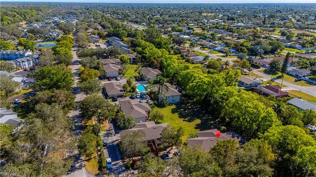 an aerial view of residential houses with outdoor space and trees
