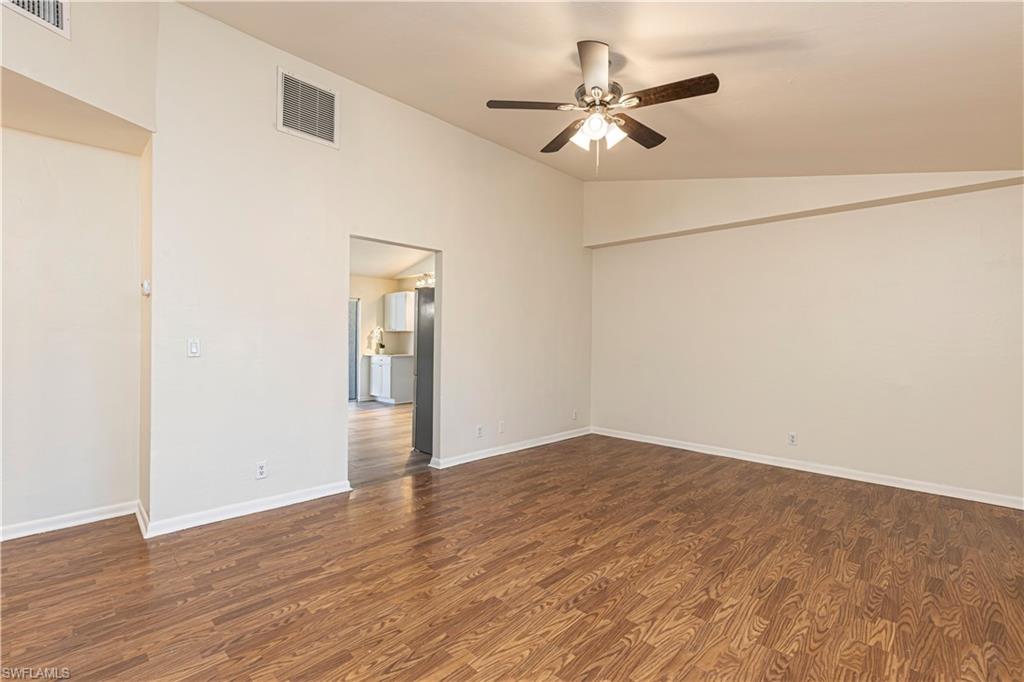 5434 16th Place Southwest, Unit D3 Golden Gate, FL 34116 - Photo 9 of 17 an empty room with wooden floor ceiling fan and a ceiling fan