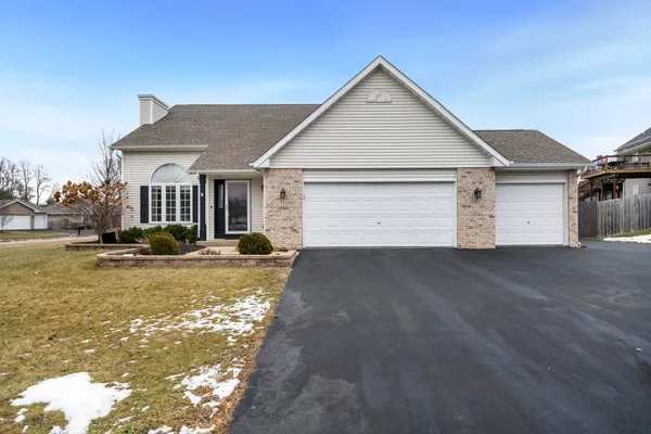 a view of a white house with a yard and garage