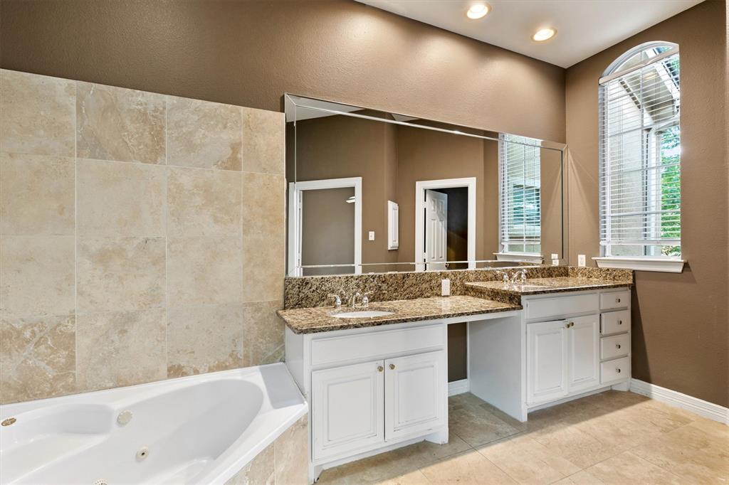 4106 Oberlin Way Addison, TX 75001 - Photo 11 of 17 a bathroom with a granite countertop sink mirror and a bathtub