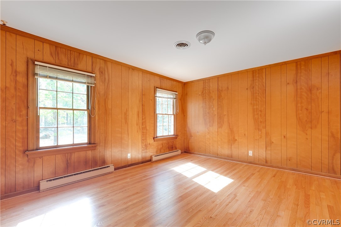 2780 East Brigstock Road Midlothian, VA 23113 - Photo 33 of 50 an empty room with wooden floor and windows with curtains view