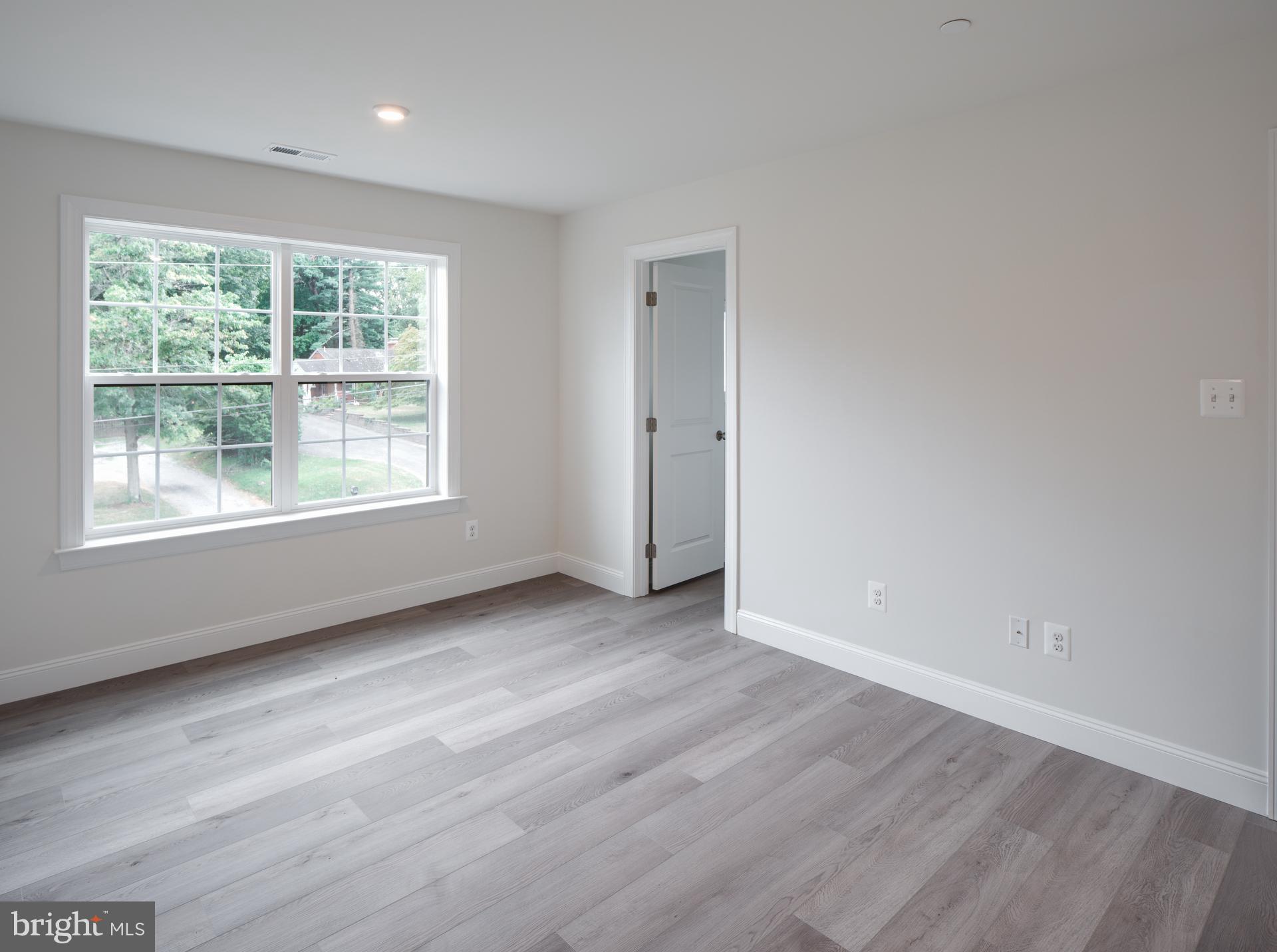 8528 Rocky Springs Road Frederick, MD 21702 - Photo 43 of 93 a view of an empty room with wooden floor and a window