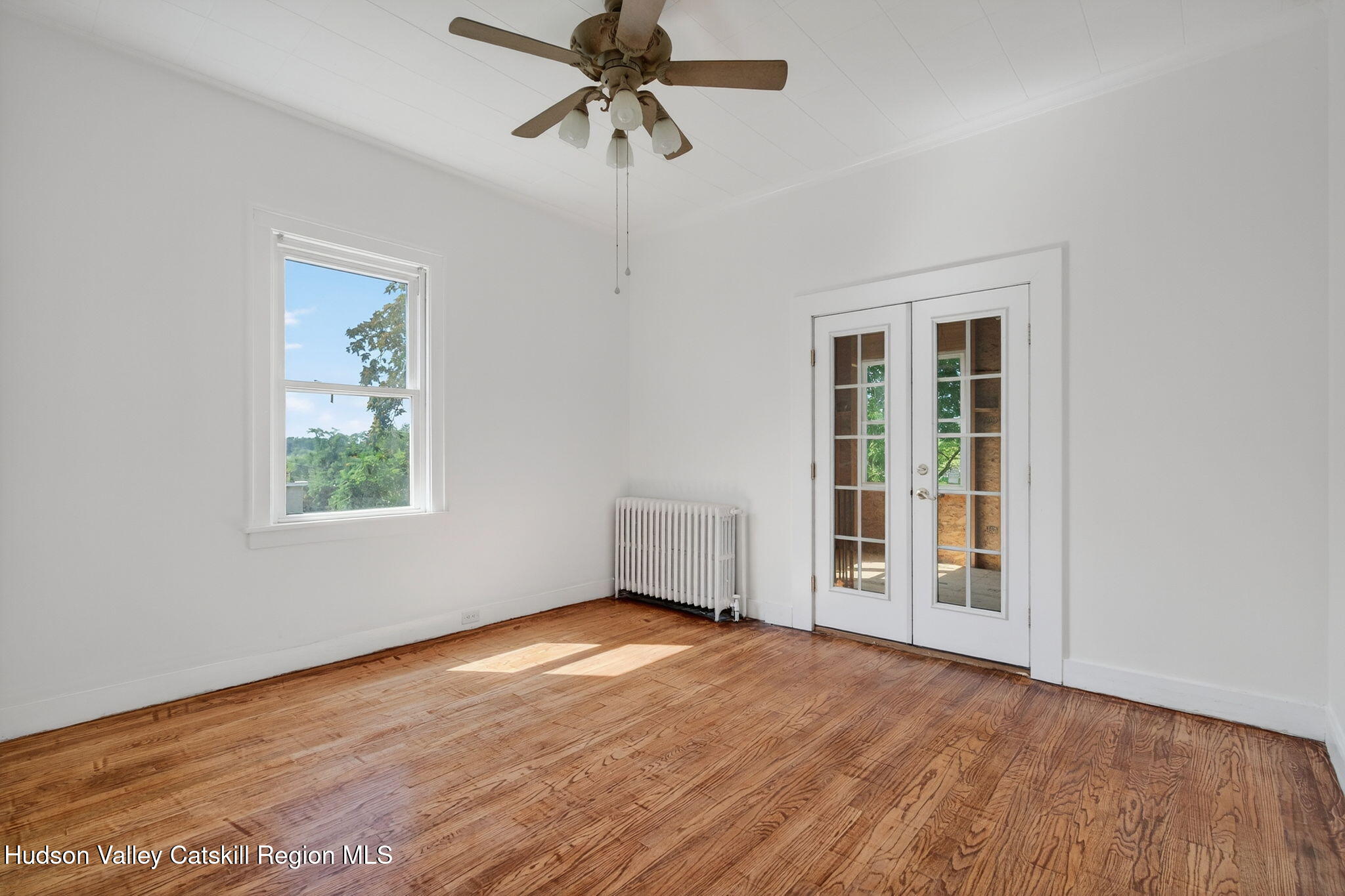 17 New Street Catskill, NY 12414 - Photo 24 of 92 an empty room with wooden floor chandelier fan and windows
