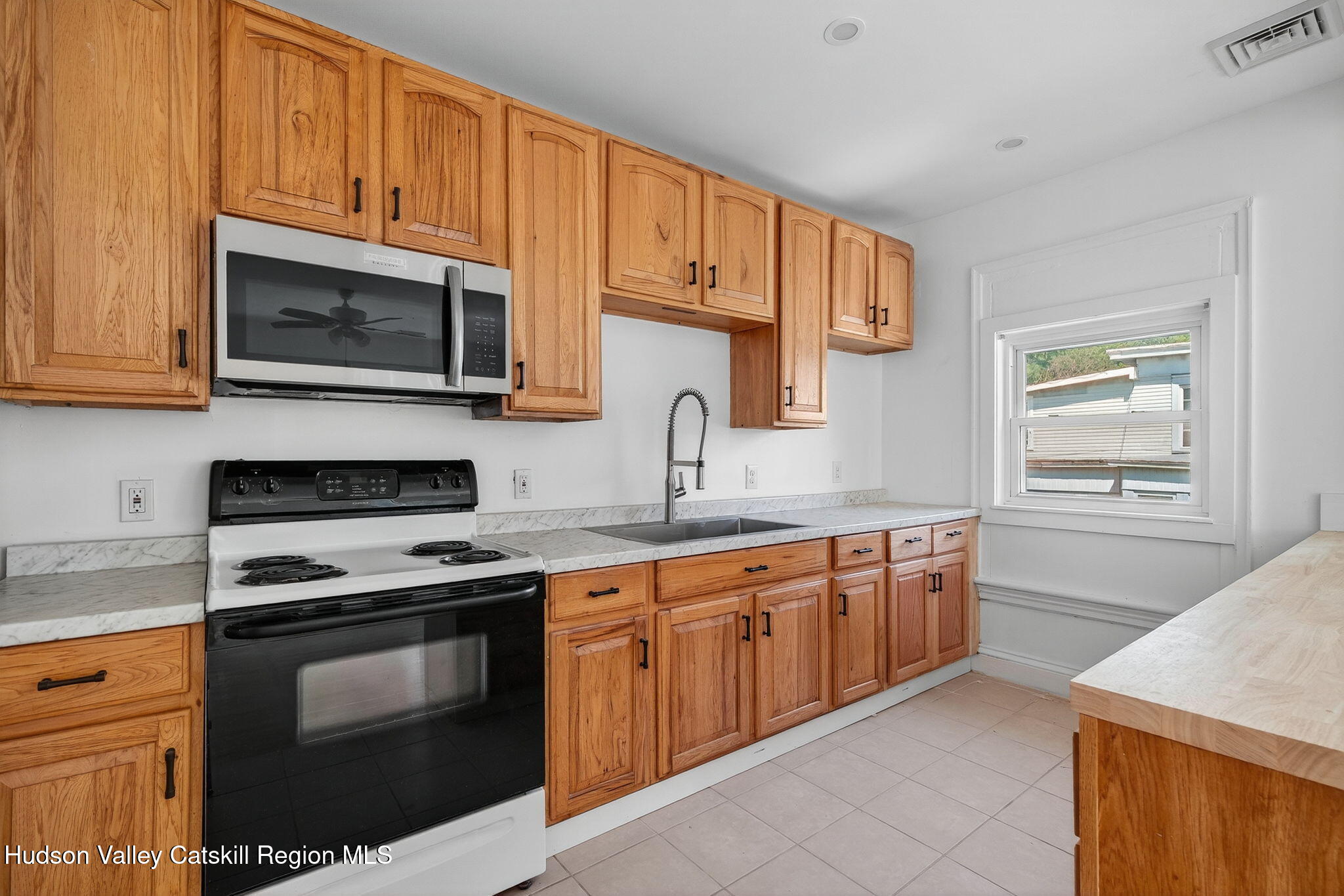 17 New Street Catskill, NY 12414 - Photo 44 of 92 a kitchen with stainless steel appliances granite countertop a stove microwave and sink