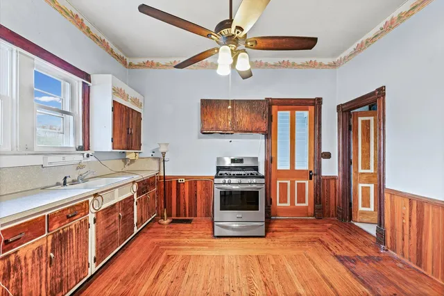 a large kitchen with stainless steel appliances granite countertop a stove a sink and a refrigerator