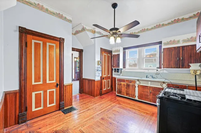a large kitchen with stainless steel appliances granite countertop a stove and a wooden floors