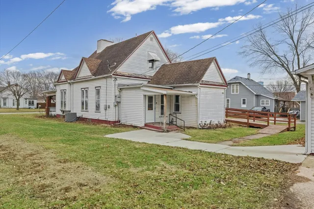 a view of a big house with a big yard and large tree