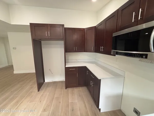 a kitchen with stainless steel appliances a wooden floor and cabinets