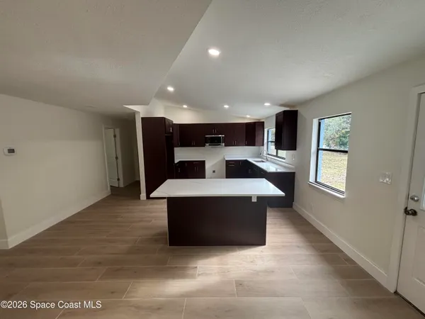 a kitchen with kitchen island stainless steel appliances a sink stove and refrigerator