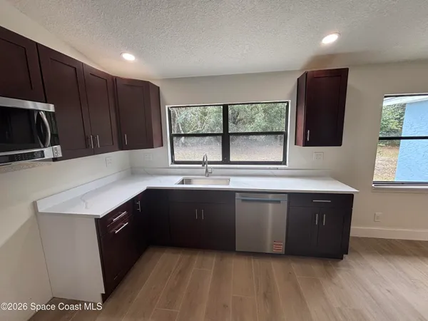 a kitchen with stainless steel appliances granite countertop a sink and a stove