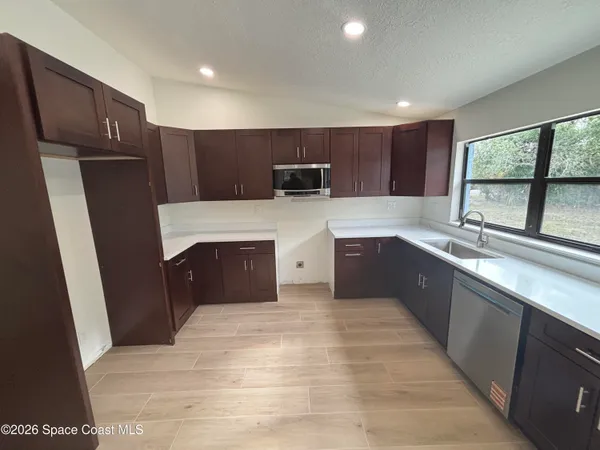 a kitchen with a refrigerator a sink and a stove top oven