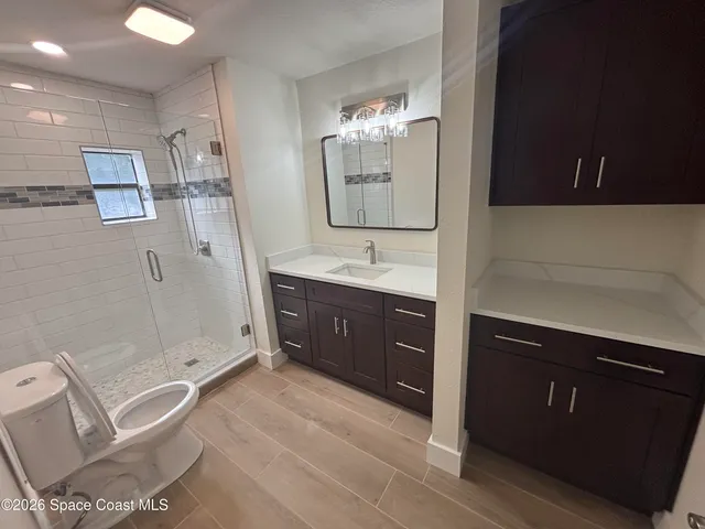 a spacious bathroom with a double vanity sink a mirror and a shower