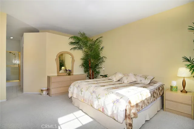 a bedroom with a bed and a potted plant