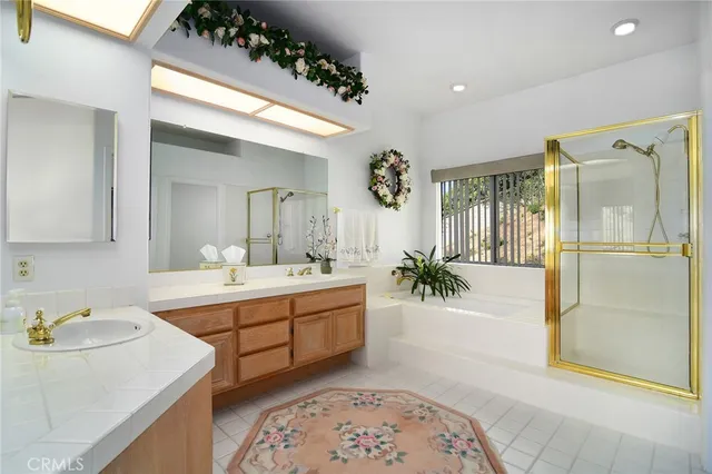 a spacious bathroom with a tub sink and mirror