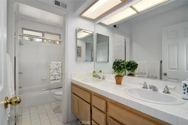 a bathroom with a double vanity sink toilet and shower