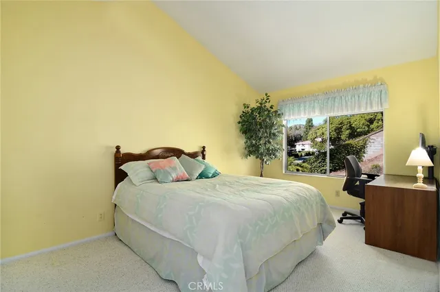 a bedroom with a bed and large windows