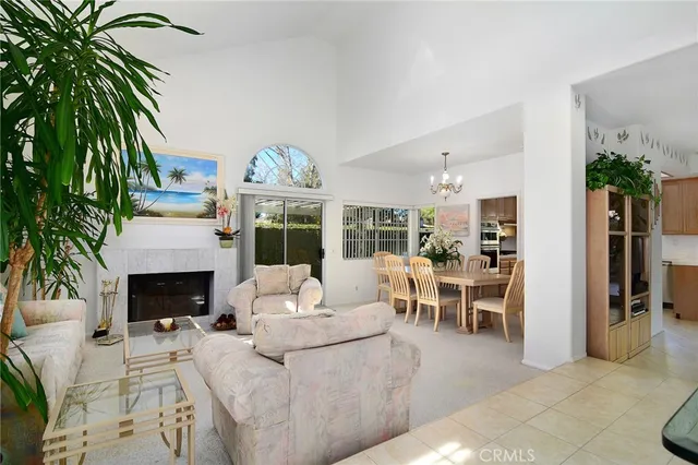 a living room with furniture fireplace and potted plants