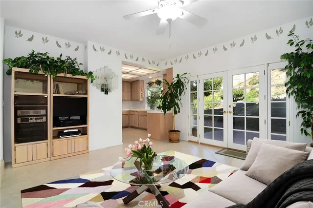 a living room with furniture a flat screen tv and a floor to ceiling window