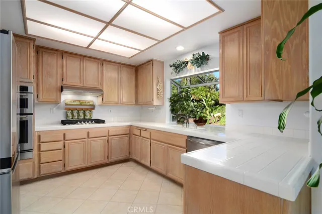 a kitchen with white cabinets and window