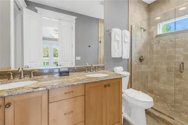 a bathroom with a granite countertop sink toilet and shower