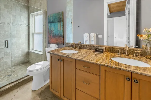 a bathroom with a granite countertop sink toilet and shower