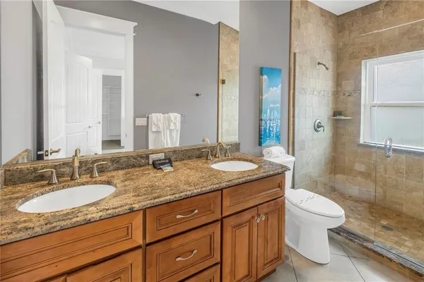 a bathroom with a granite countertop sink toilet and shower