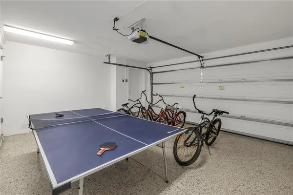 a room with gym equipment and wooden floor