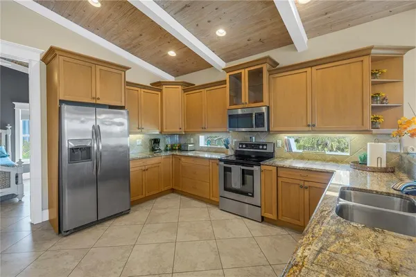 a kitchen with stainless steel appliances granite countertop a refrigerator a stove top oven a sink and dishwasher