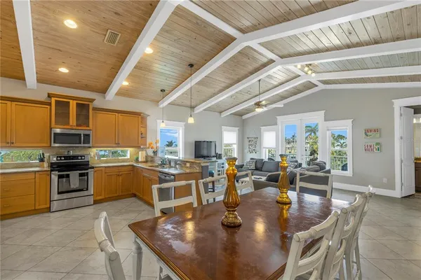 a large dining hall with stainless steel appliances granite countertop a stove granite counter tops and white cabinets