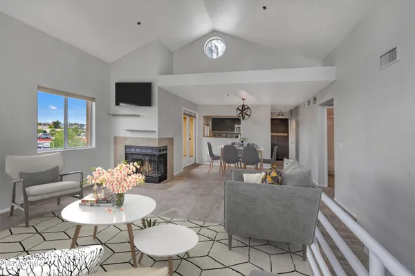 a living room with furniture a fireplace and a flat screen tv