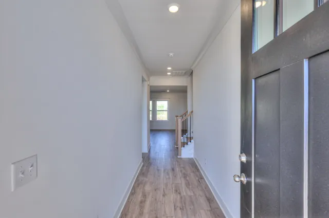 a view of a hallway with wooden floor and entryway