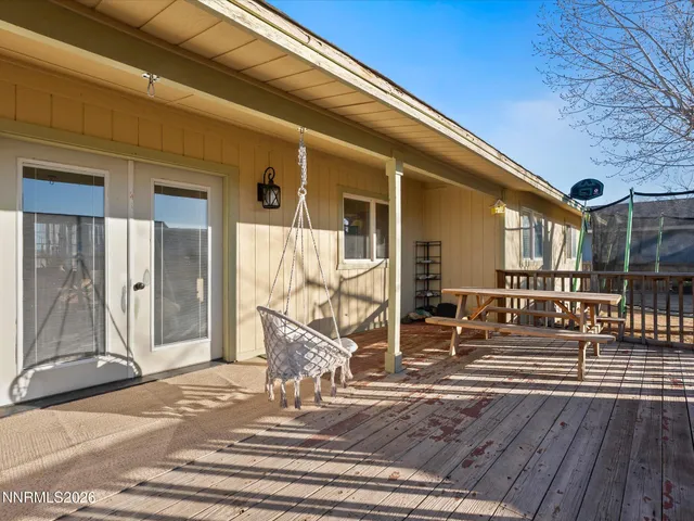 a view of a house with a wooden deck and furniture
