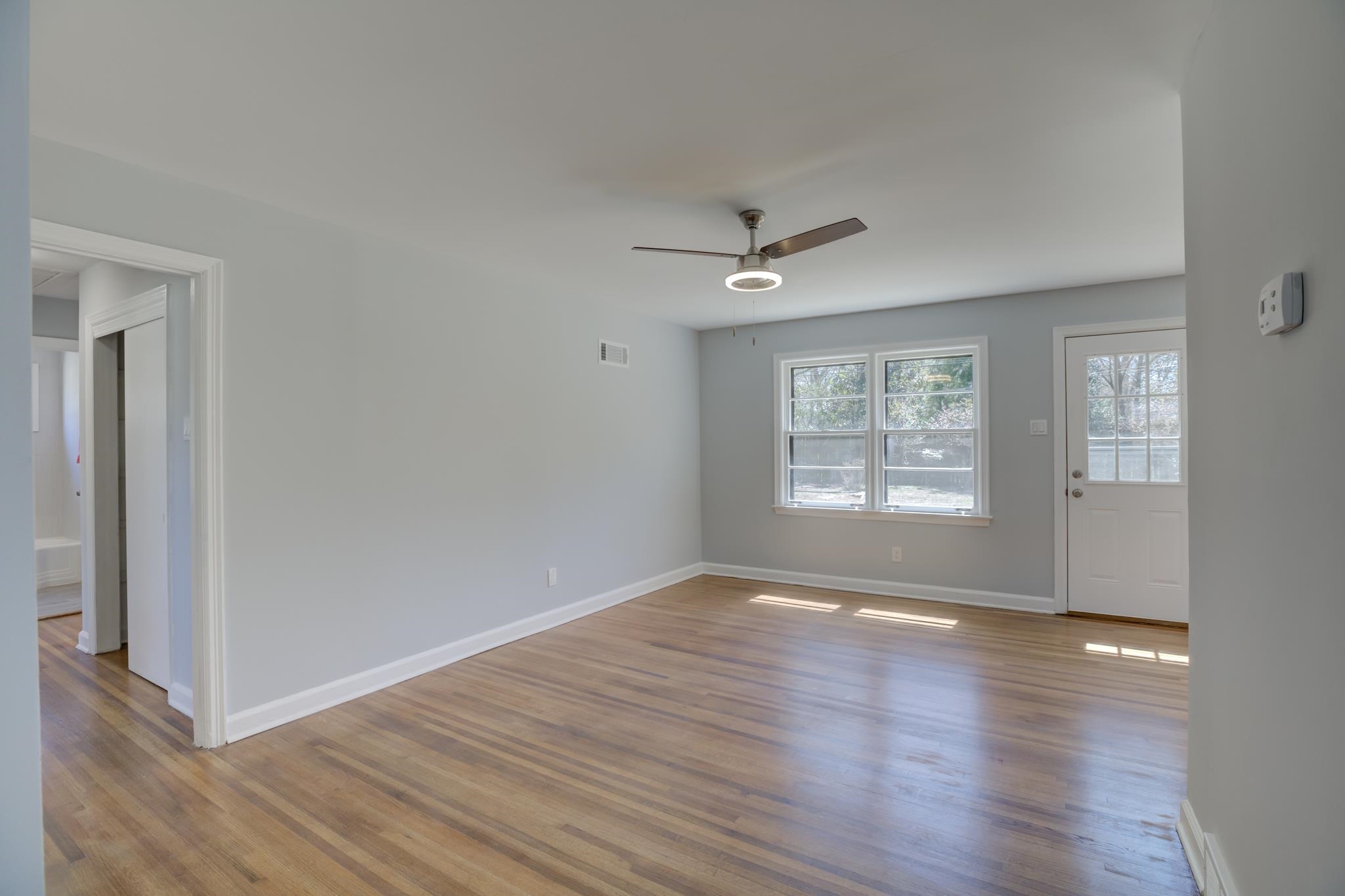4999 Chickasaw Road Memphis, TN 38117 - Photo 13 of 25 a view of an empty room with wooden floor and a window