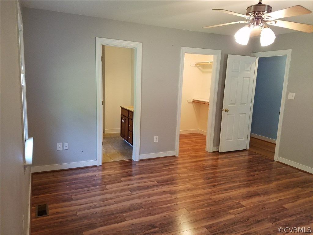 2238 Wickham Road Bumpass, VA 23024 - Photo 6 of 15 an empty room with wooden floor and ceiling fan